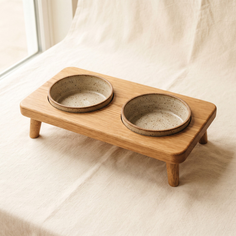 Raised Oak Double Feeder: an oiled solid oak stand holding two stoneware bowls