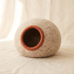 Felted Wool Cat Cave, a round seamless cave hand-felted from undyed wool with a terracotta rim